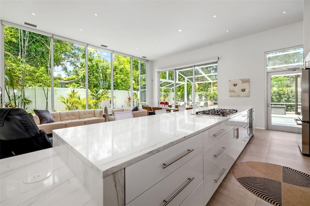 904 Virginia Dr, Sarasota, FL 34234 - kitchen with appliances with stainless steel finishes, white cabinets, light stone counters, modern cabinets, and recessed lighting