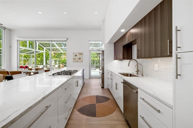 904 Virginia Dr, Sarasota, FL 34234 - kitchen with appliances with stainless steel finishes, tasteful backsplash, white cabinets, light tile patterned flooring, and recessed lighting