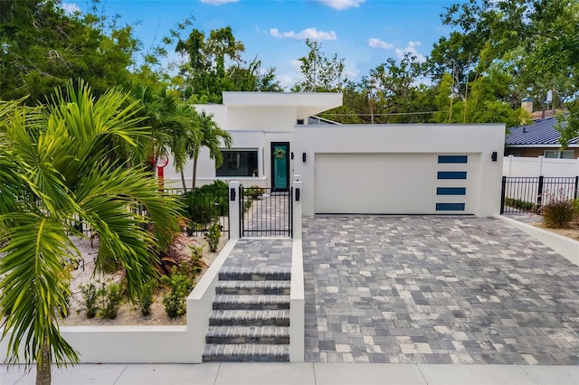 904 Virginia Dr, Sarasota, FL 34234 - contemporary home featuring an attached garage, stucco siding, decorative driveway, and a gate
