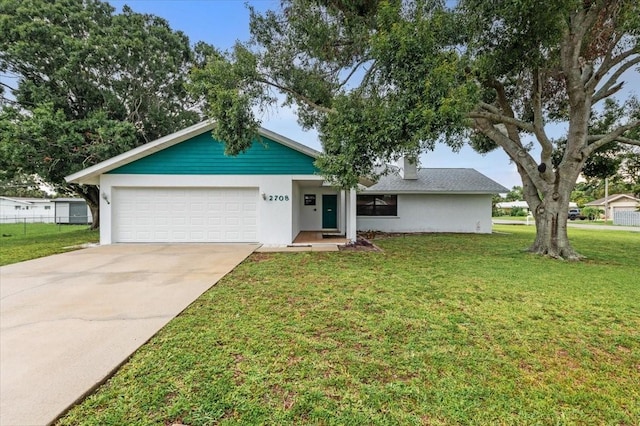 2708 Wilkinson Rd, Sarasota, FL 34231 - view of front facade with driveway, an attached garage, a front lawn, and stucco siding