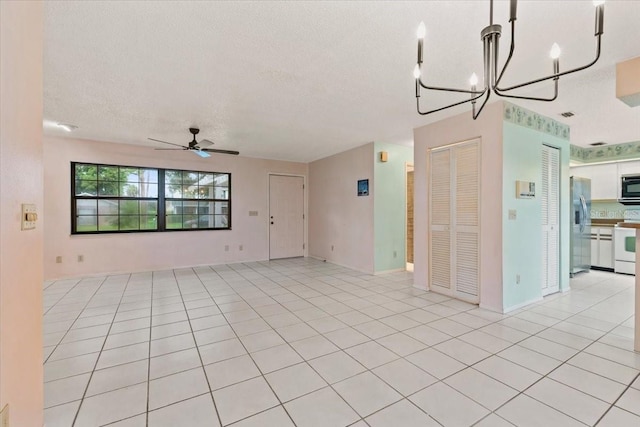 2708 Wilkinson Rd, Sarasota, FL 34231 - spare room with a textured ceiling, a ceiling fan, a chandelier, and light tile patterned flooring