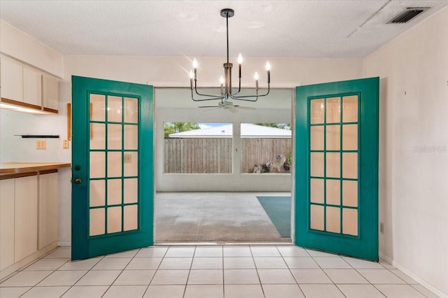 2708 Wilkinson Rd, Sarasota, FL 34231 - doorway with a chandelier, light tile patterned floors, light carpet, and a textured ceiling