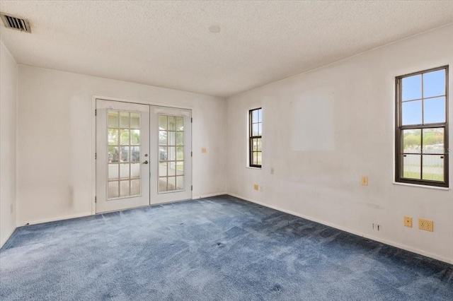 2708 Wilkinson Rd, Sarasota, FL 34231 - empty room with french doors, dark colored carpet, and a textured ceiling