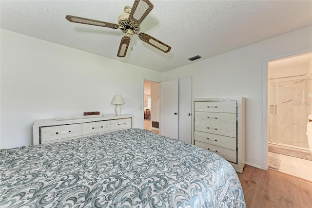 3905 34th Avenue Dr W Unit 36, Bradenton, FL 34205 - bedroom featuring wood finished floors, a textured ceiling, a ceiling fan, and ensuite bath