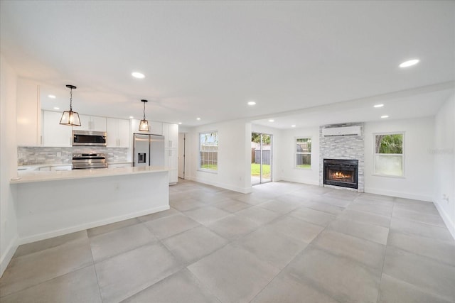 3959 Coleridge Pl, Sarasota, FL 34241 - kitchen with appliances with stainless steel finishes, a wall mounted AC, recessed lighting, white cabinets, and light countertops