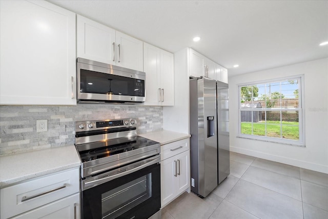3959 Coleridge Pl, Sarasota, FL 34241 - kitchen featuring stainless steel appliances, decorative backsplash, light tile patterned floors, white cabinetry, and recessed lighting