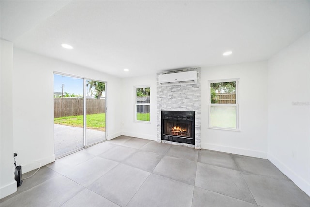 3959 Coleridge Pl, Sarasota, FL 34241 - unfurnished living room featuring a wall mounted air conditioner, a stone fireplace, healthy amount of natural light, and recessed lighting