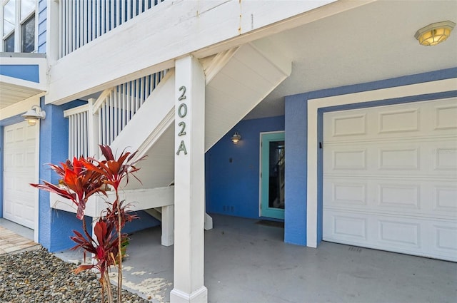 202 75th St, Holmes Beach, FL 34217 - property entrance with a garage and stucco siding