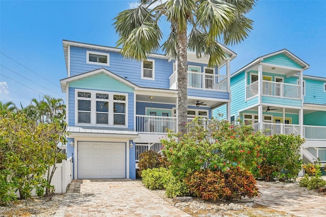 202 75th St, Holmes Beach, FL 34217 - view of front of property with ceiling fan, a balcony, an attached garage, and driveway