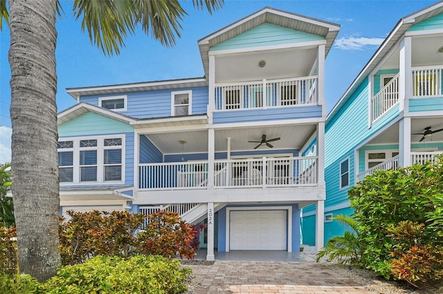202 75th St, Holmes Beach, FL 34217 - raised beach house featuring ceiling fan, a balcony, a garage, driveway, and covered porch