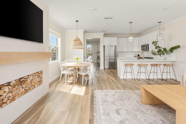12017 Cranston Way, Bradenton, FL 34211 - kitchen with stainless steel appliances, a breakfast bar, light countertops, white cabinets, and a peninsula