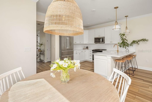 12017 Cranston Way, Bradenton, FL 34211 - dining area featuring light wood-style flooring and crown molding