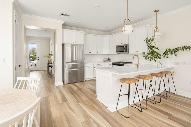 12017 Cranston Way, Bradenton, FL 34211 - kitchen featuring stainless steel appliances, a peninsula, a kitchen breakfast bar, white cabinets, and backsplash