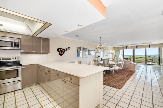 546A Beach Rd Unit A544, Sarasota, FL 34242 - kitchen with stainless steel appliances, open floor plan, a peninsula, light tile patterned flooring, and a chandelier