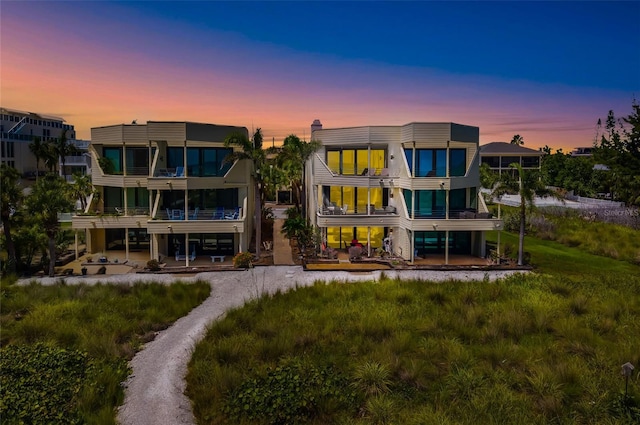 546A Beach Rd Unit A544, Sarasota, FL 34242 - back of property at dusk featuring a balcony and a patio