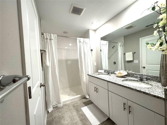 5812 Ocean Isle Dr, Nokomis, FL 34275 - full bathroom featuring double vanity, a stall shower, tile patterned flooring, and a textured ceiling