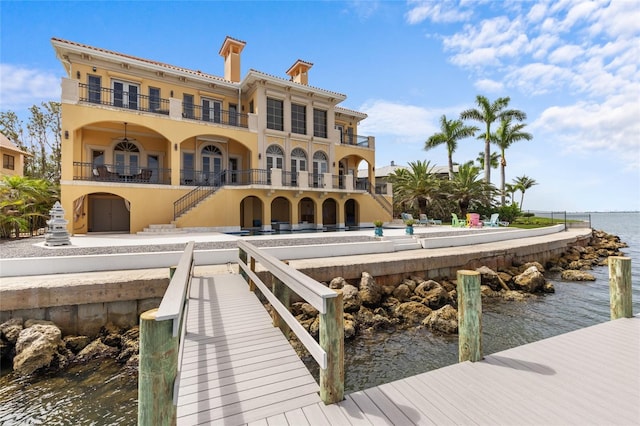 309 Ringling Point Dr, Sarasota, FL 34234 - back of house featuring a balcony, a water view, stairway, and a chimney