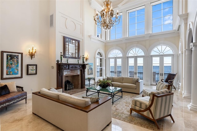 309 Ringling Point Dr, Sarasota, FL 34234 - living area with a high ceiling, a high end fireplace, a chandelier, decorative columns, and crown molding