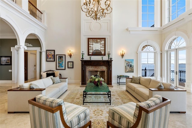 309 Ringling Point Dr, Sarasota, FL 34234 - living area featuring a high ceiling, a chandelier, a premium fireplace, french doors, and ornate columns
