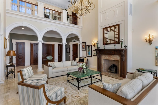 309 Ringling Point Dr, Sarasota, FL 34234 - living area with a towering ceiling, decorative columns, a chandelier, ornamental molding, and a premium fireplace