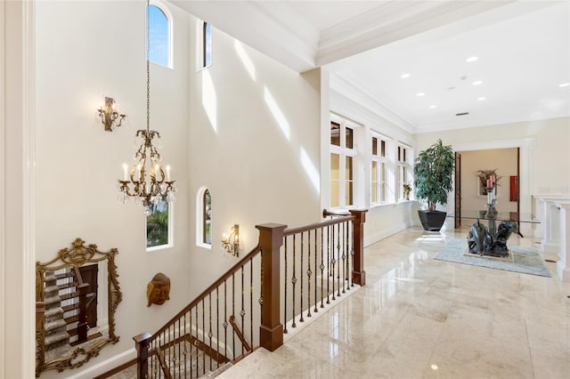 309 Ringling Point Dr, Sarasota, FL 34234 - hallway with healthy amount of natural light, a chandelier, an upstairs landing, crown molding, and a high ceiling