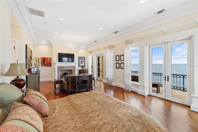 309 Ringling Point Dr, Sarasota, FL 34234 - living room featuring french doors, ornamental molding, wood finished floors, a chandelier, and a fireplace