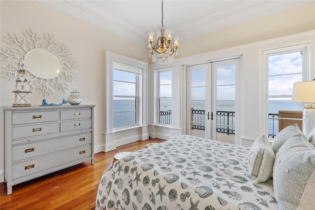 309 Ringling Point Dr, Sarasota, FL 34234 - bedroom with access to outside, french doors, a chandelier, light wood-type flooring, and a water view