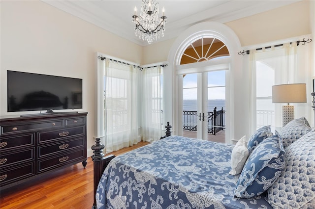 309 Ringling Point Dr, Sarasota, FL 34234 - bedroom featuring french doors, wood finished floors, a chandelier, and a water view