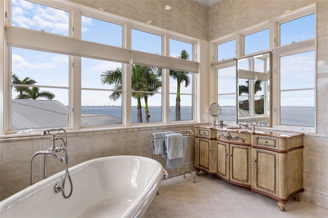 309 Ringling Point Dr, Sarasota, FL 34234 - full bathroom with a freestanding bath, healthy amount of natural light, vanity, tile walls, and a water view