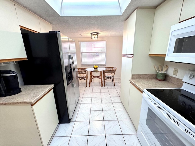 6505 Stone River Rd Unit 309, Bradenton, FL 34203 - kitchen featuring white appliances, light countertops, a textured ceiling, and white cabinetry