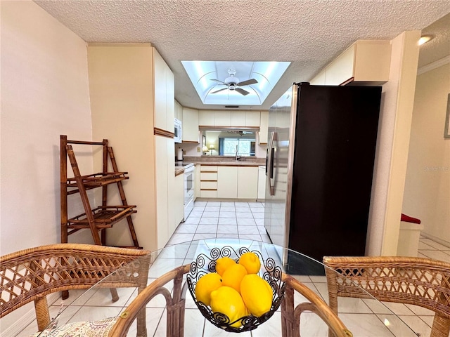 6505 Stone River Rd Unit 309, Bradenton, FL 34203 - kitchen featuring white appliances, a skylight, light tile patterned flooring, white cabinetry, and a textured ceiling