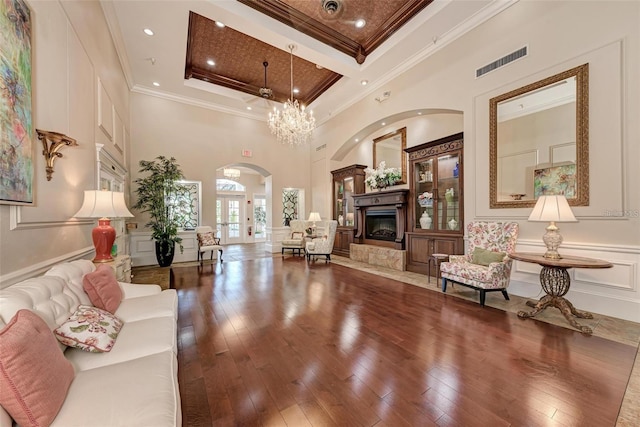 6505 Stone River Rd Unit 309, Bradenton, FL 34203 - living room with arched walkways, crown molding, a towering ceiling, a decorative wall, and hardwood / wood-style floors