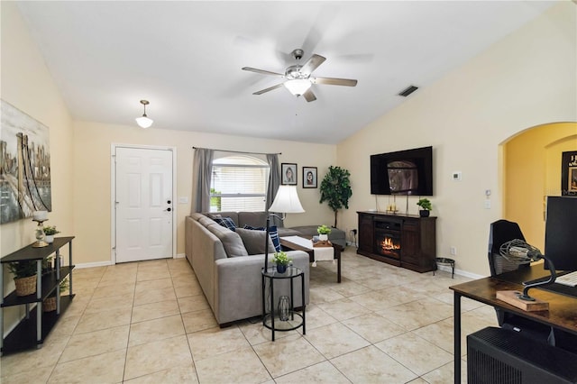 4649 72nd Ct E, Bradenton, FL 34203 - living area with vaulted ceiling, ceiling fan, light tile patterned floors, arched walkways, and a lit fireplace