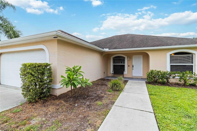4649 72nd Ct E, Bradenton, FL 34203 - entrance to property with an attached garage, stucco siding, a lawn, and a shingled roof