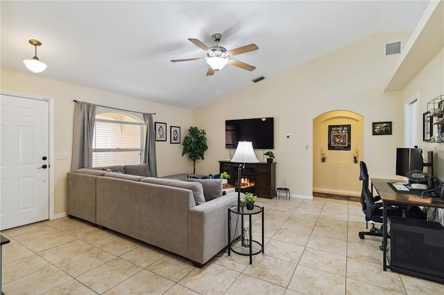 4649 72nd Ct E, Bradenton, FL 34203 - living room with lofted ceiling, light tile patterned flooring, ceiling fan, a lit fireplace, and arched walkways