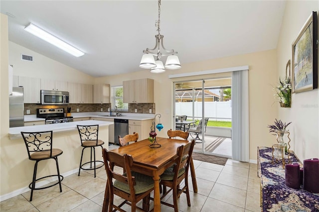 4649 72nd Ct E, Bradenton, FL 34203 - dining space featuring vaulted ceiling, light tile patterned flooring, and a chandelier