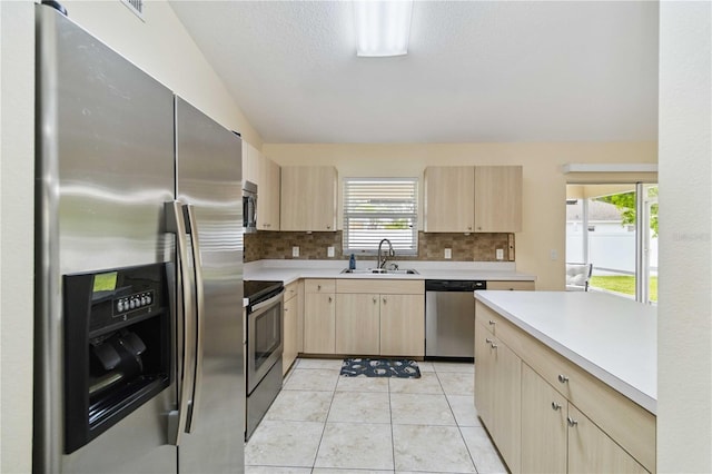 4649 72nd Ct E, Bradenton, FL 34203 - kitchen featuring appliances with stainless steel finishes, light brown cabinets, light countertops, lofted ceiling, and decorative backsplash