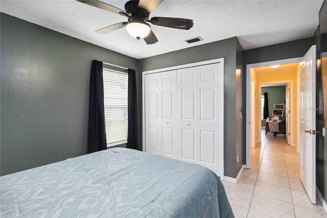 4649 72nd Ct E, Bradenton, FL 34203 - bedroom with light tile patterned flooring, a closet, ceiling fan, and a textured ceiling