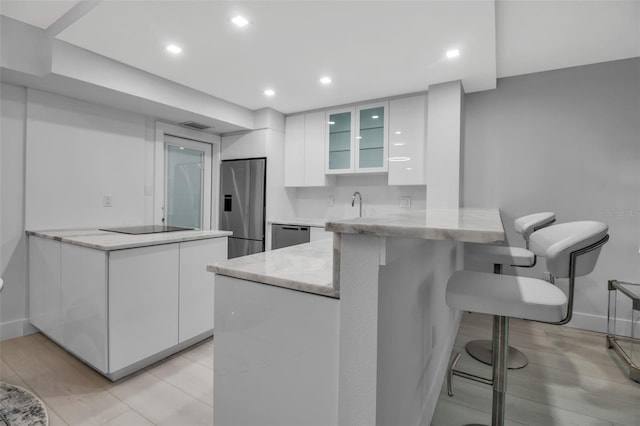 1150 Tarpon Center Dr Unit 1-C # 103, Venice, FL 34285 - kitchen with appliances with stainless steel finishes, a peninsula, white cabinets, modern cabinets, and recessed lighting