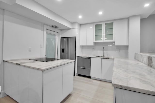 1150 Tarpon Center Dr Unit 1-C # 103, Venice, FL 34285 - kitchen featuring appliances with stainless steel finishes, white cabinetry, a peninsula, modern cabinets, and glass insert cabinets