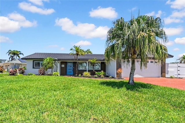 8001 13th Ave S, Saint Petersburg, FL 33707 - view of front of home with a tile roof, stucco siding, decorative driveway, and a front lawn
