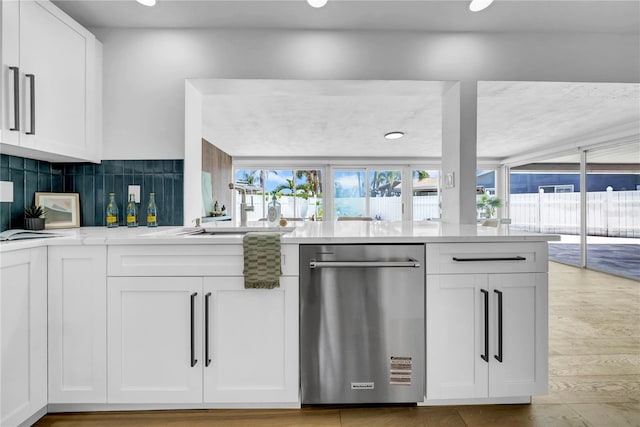 8001 13th Ave S, Saint Petersburg, FL 33707 - kitchen with stainless steel dishwasher, white cabinets, tasteful backsplash, and light wood-style floors