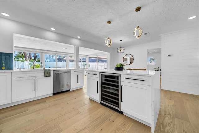 8001 13th Ave S, Saint Petersburg, FL 33707 - kitchen featuring wine cooler, dishwasher, plenty of natural light, white cabinets, and recessed lighting