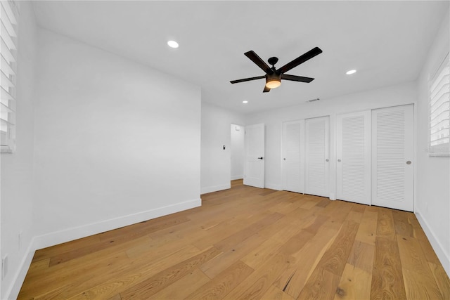 8001 13th Ave S, Saint Petersburg, FL 33707 - unfurnished bedroom featuring two closets, light wood-type flooring, recessed lighting, and ceiling fan