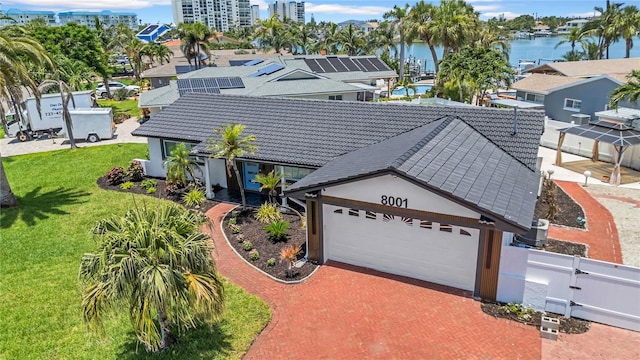 8001 13th Ave S, Saint Petersburg, FL 33707 - view of front of property featuring a tile roof, a garage, a water view, and stucco siding