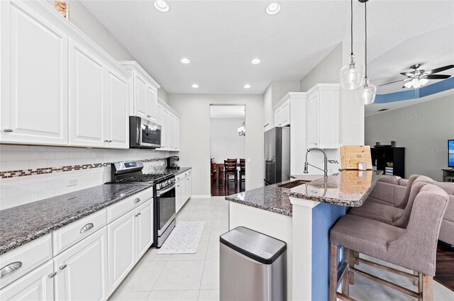 4654 Claremont Park Dr, Bradenton, FL 34211 - kitchen featuring stainless steel appliances, decorative backsplash, recessed lighting, white cabinetry, and dark stone counters