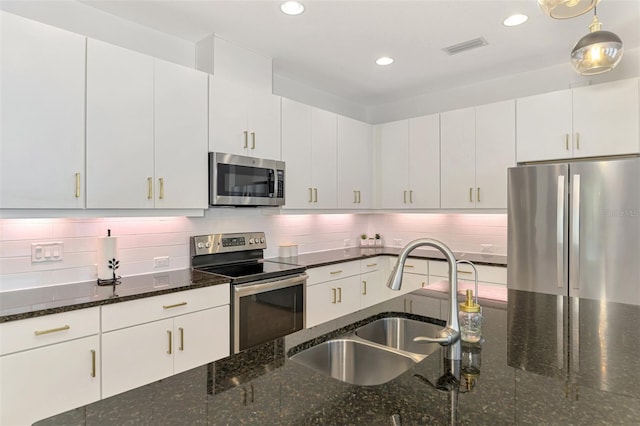 3602 Secret Stroll Dr, Sarasota, FL 34240 - kitchen with appliances with stainless steel finishes, backsplash, recessed lighting, hanging light fixtures, and dark stone countertops