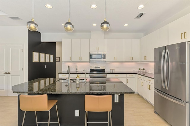 3602 Secret Stroll Dr, Sarasota, FL 34240 - kitchen with stainless steel appliances, a kitchen bar, recessed lighting, backsplash, and white cabinetry