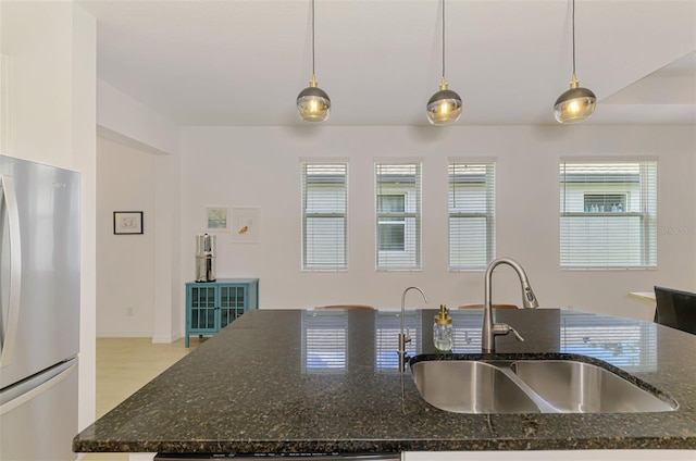 3602 Secret Stroll Dr, Sarasota, FL 34240 - kitchen with freestanding refrigerator, pendant lighting, and dark stone counters