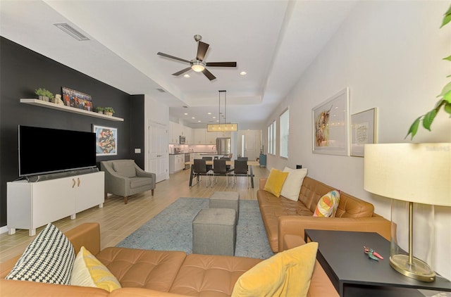 3602 Secret Stroll Dr, Sarasota, FL 34240 - living area with a ceiling fan, light wood finished floors, a raised ceiling, and recessed lighting
